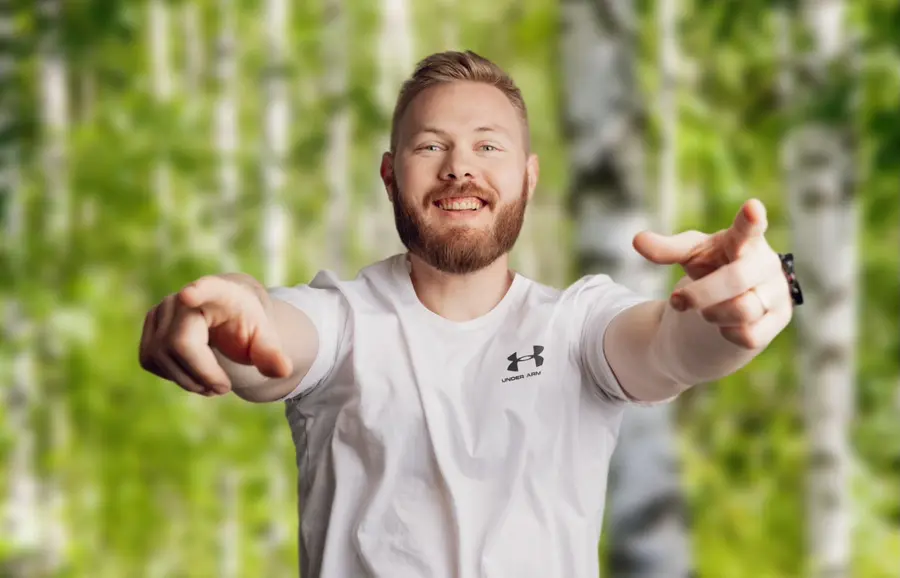 Hymyilevä valmentaja osoittaa kohti katsojaa